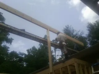 Carpenter setting a ridge beam over a new addition frame — Ice Dam Removal by Roofing Brothers in Etta