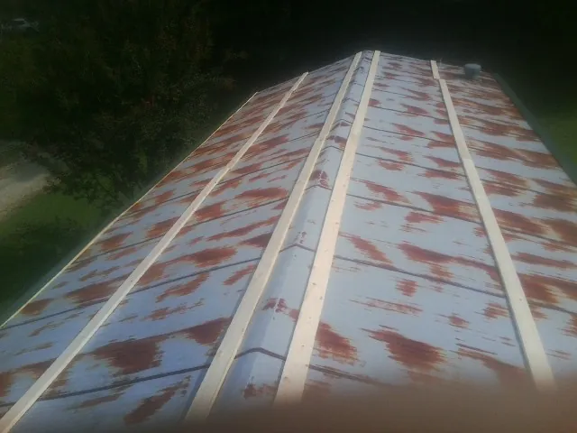 Rusted metal roof panels with new wood purlins before replacement — Storm Damage Roof Repair in Etta by Roofing Brothers