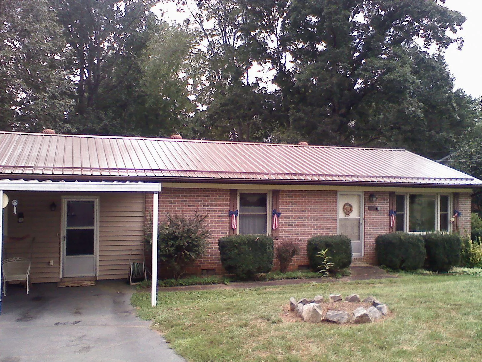 Bronze metal roof and carport on a brick ranch home — Roof Repair work by our crew in Etta